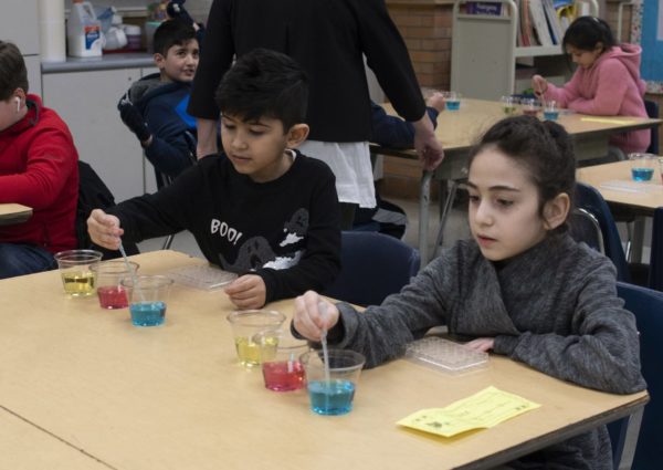 Two students conduct a science experiment at Nowlin Elementary STEAM Night in February 2020.