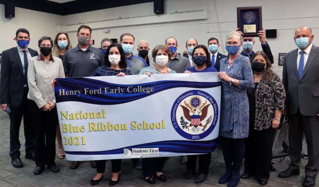 A group of school, district and Henry Ford College representatives pose with a sign celebrating Henry Ford Early College receiving a 2021 National Blue Ribbon School Award.