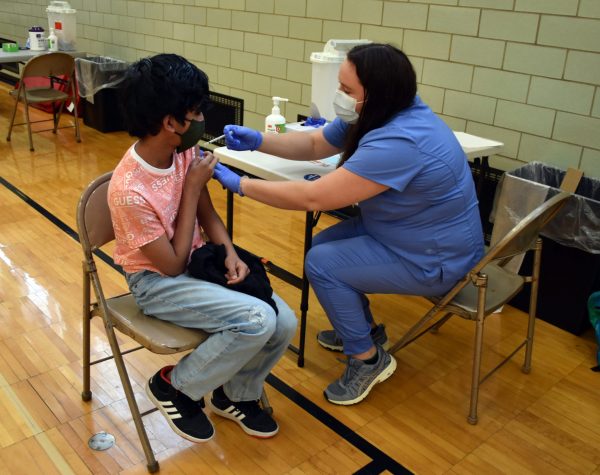 A student receives a COVID vaccine during a clinic at Edsel Ford High School in May 2021.