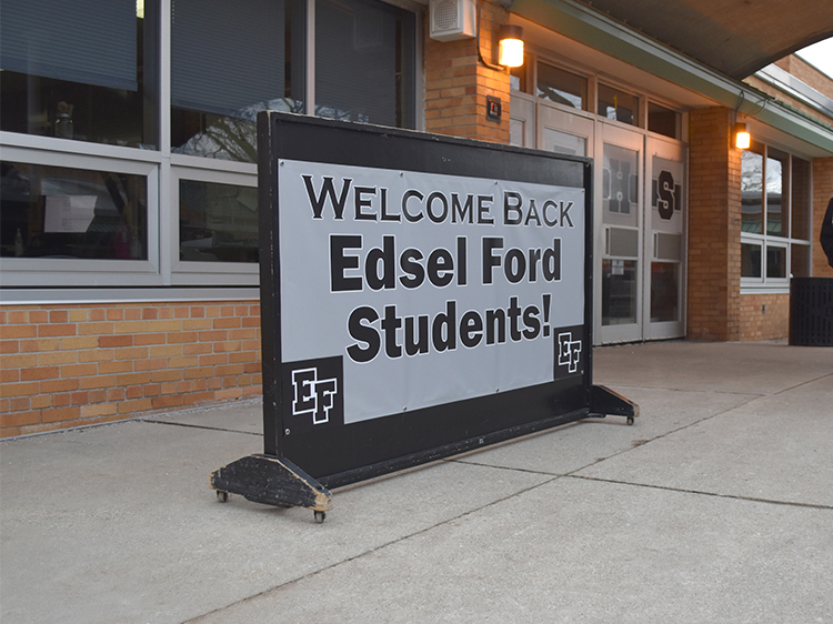 A sign outside the high school doors says "Welcome Back Edsel Ford Students"