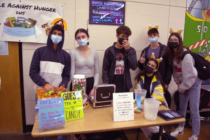 Six Dearborn High students stand around a table fundraising for Battle Against Hunger in 2021.