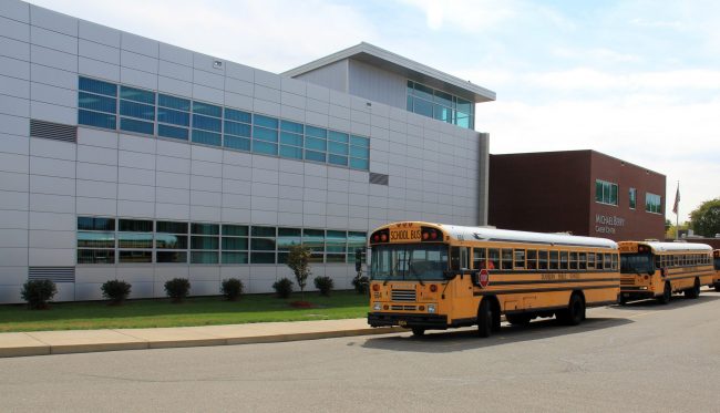 Exterior of Michael Berry Career Center with two buses in front
