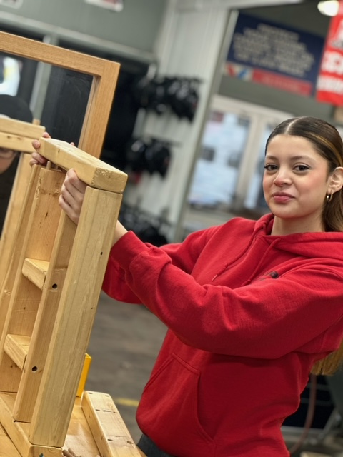 A student assembles a wooden frame during a Tools for Schools event at Edsel Ford High