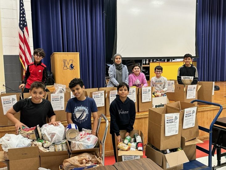 Eight students pack donated food during the 2023 Battle Against Hunger at Miller Elementary