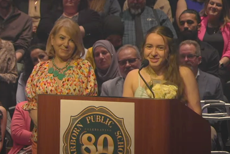 A student talks about her teacher, who is standing nearby, during the 2025 Superintendent's Honors Night.